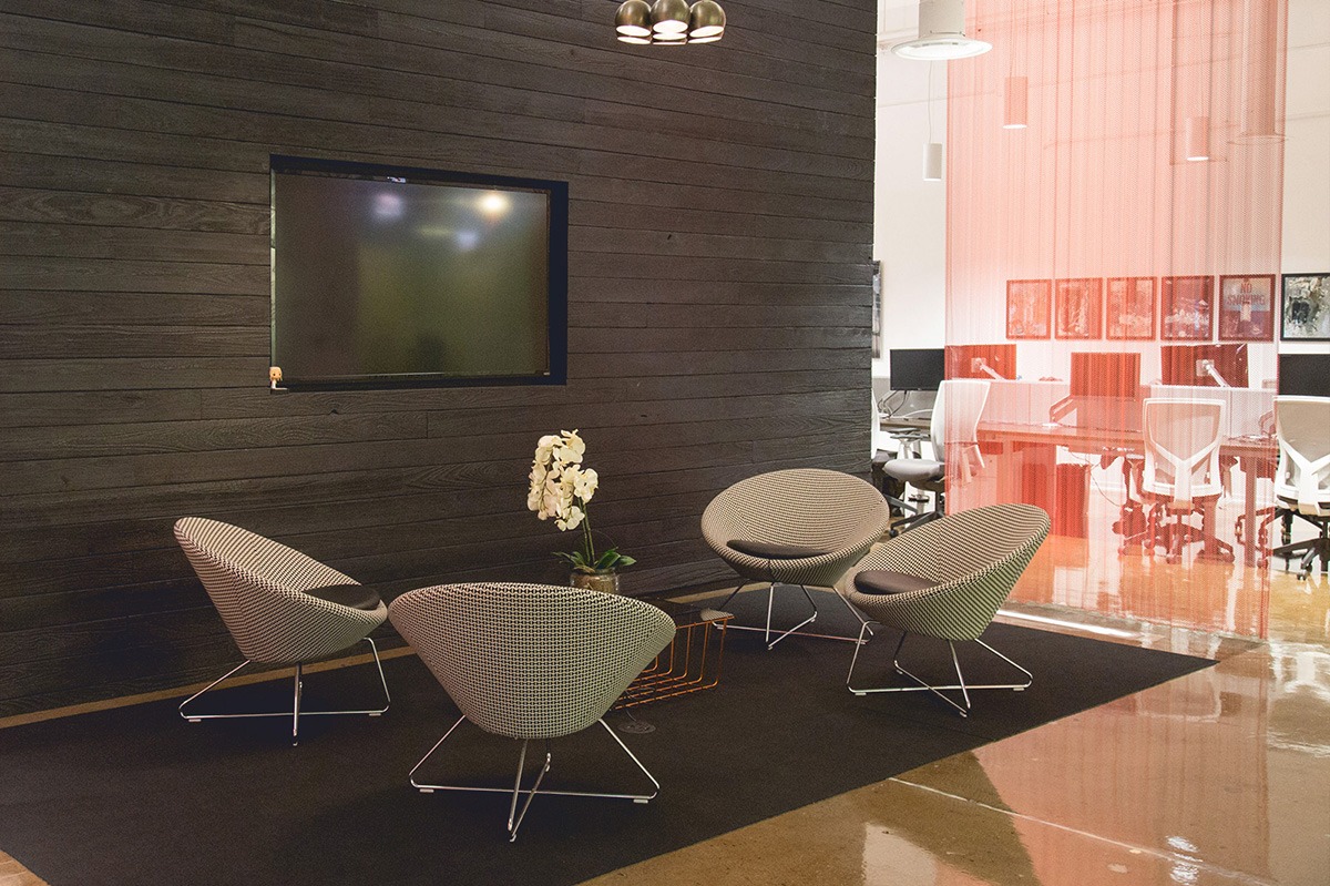 A seating area in Vail’s office with woven chairs and orange partitions