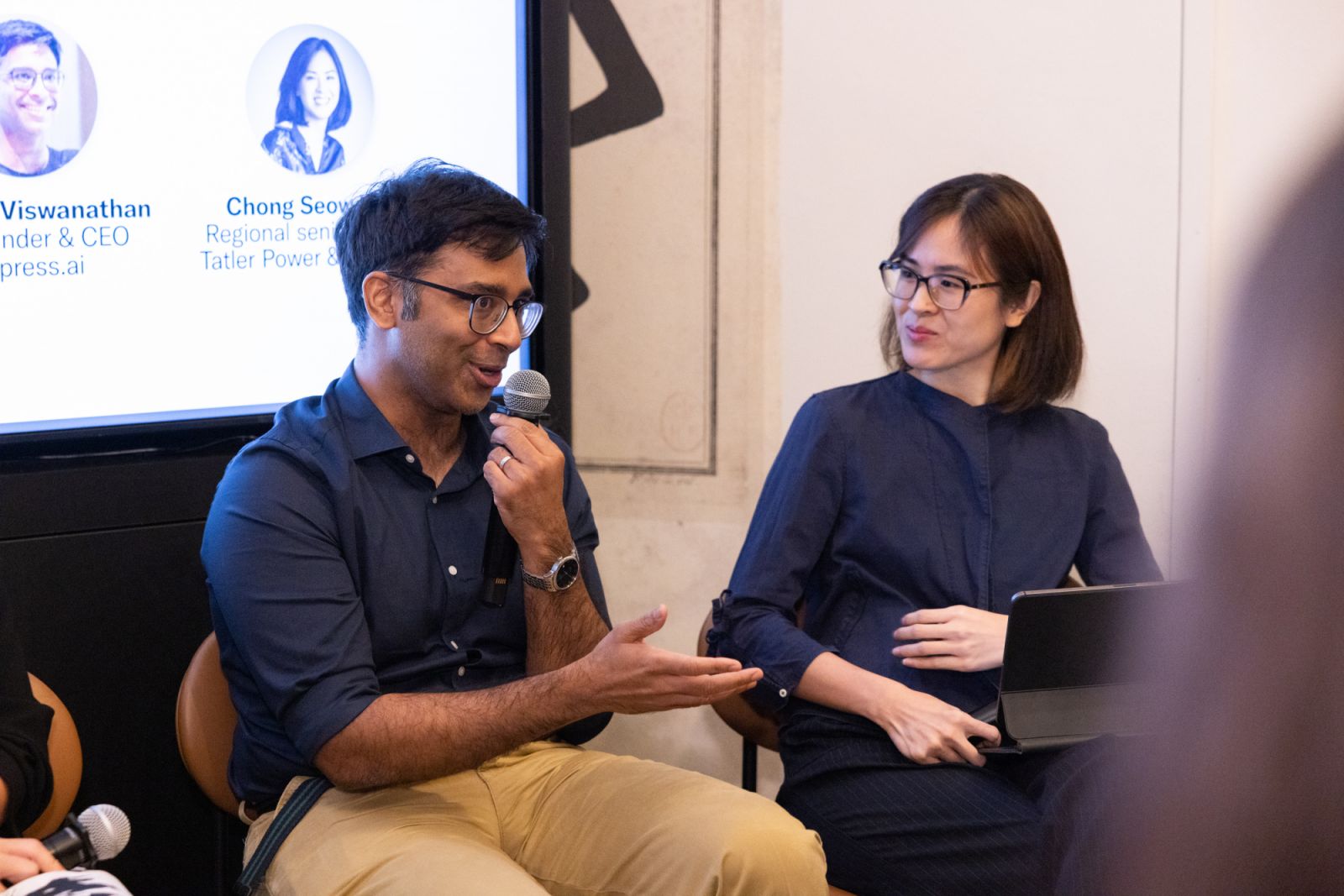 Vaisagh Viswanathan speaking into a microphone beside moderator Chong Seow Wei at Tatler House