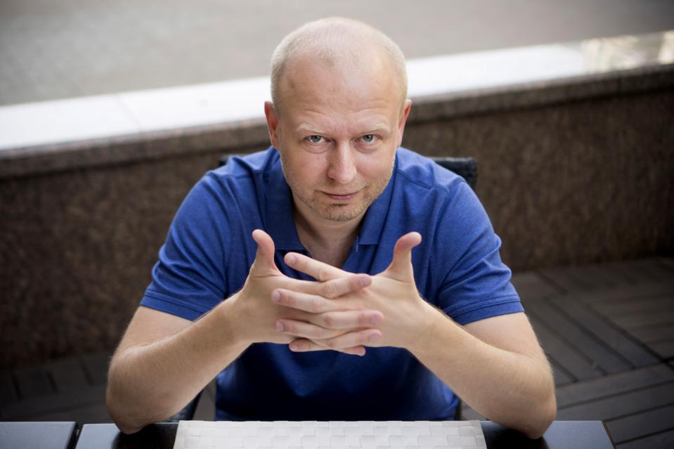 Valery Vavilov seated outdoors in Kyiv, hands clasped