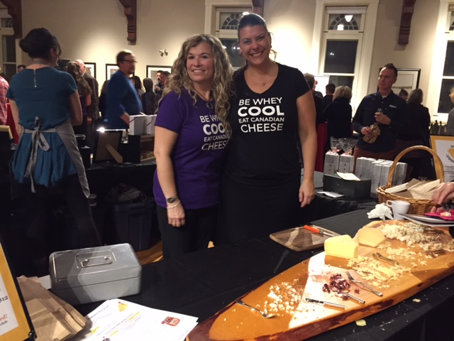 Vanessa Simmons, right, with a colleague beside a long board of Canadian artisan cheeses at an Ontario tasting event