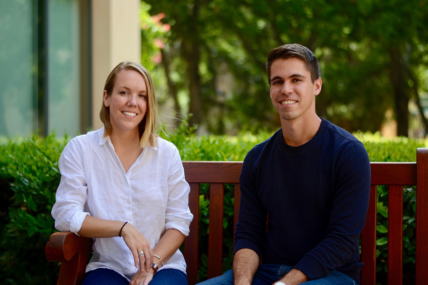 Vannevar Labs co-founders Nini Hamrick and Brett Granberg seated on a bench outdoors