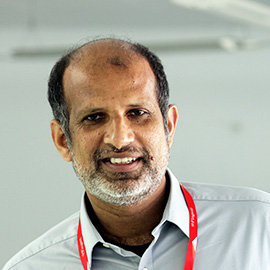 Varghese Samuel wearing an open-collar shirt and a red lanyard in Fingent’s official leadership photograph