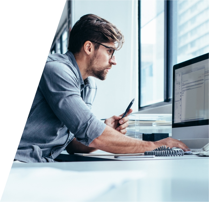 A man reviewing information on a desktop screen in vAuto’s illustrative company-site photograph