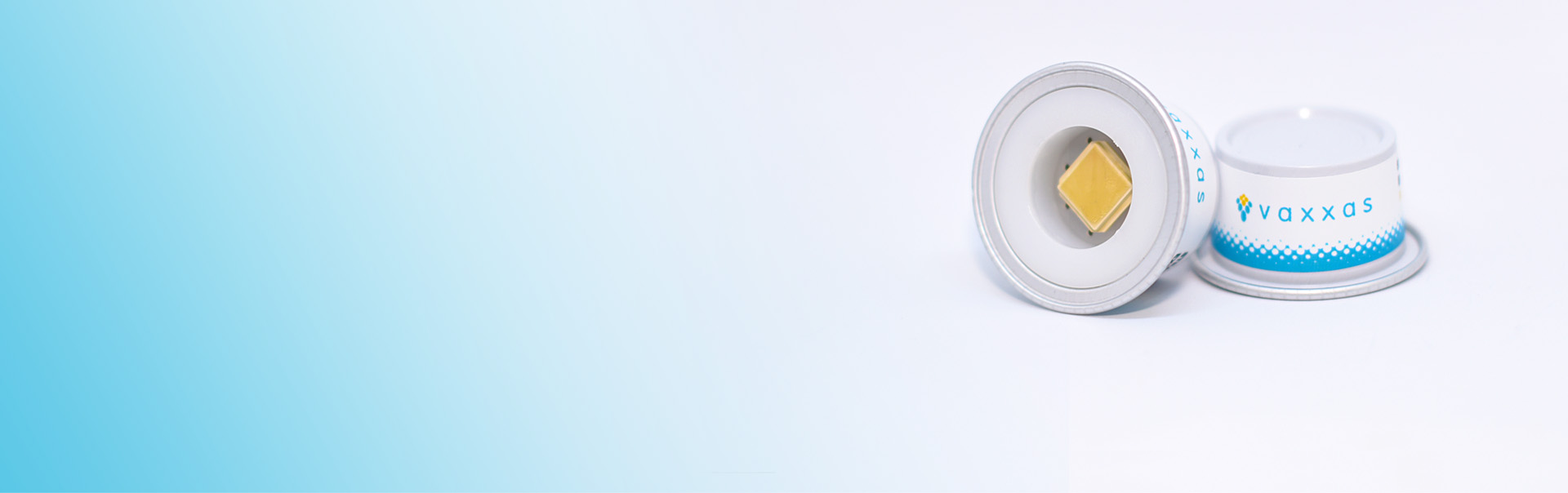 Two Vaxxas applicators, one showing the small vaccine patch inside