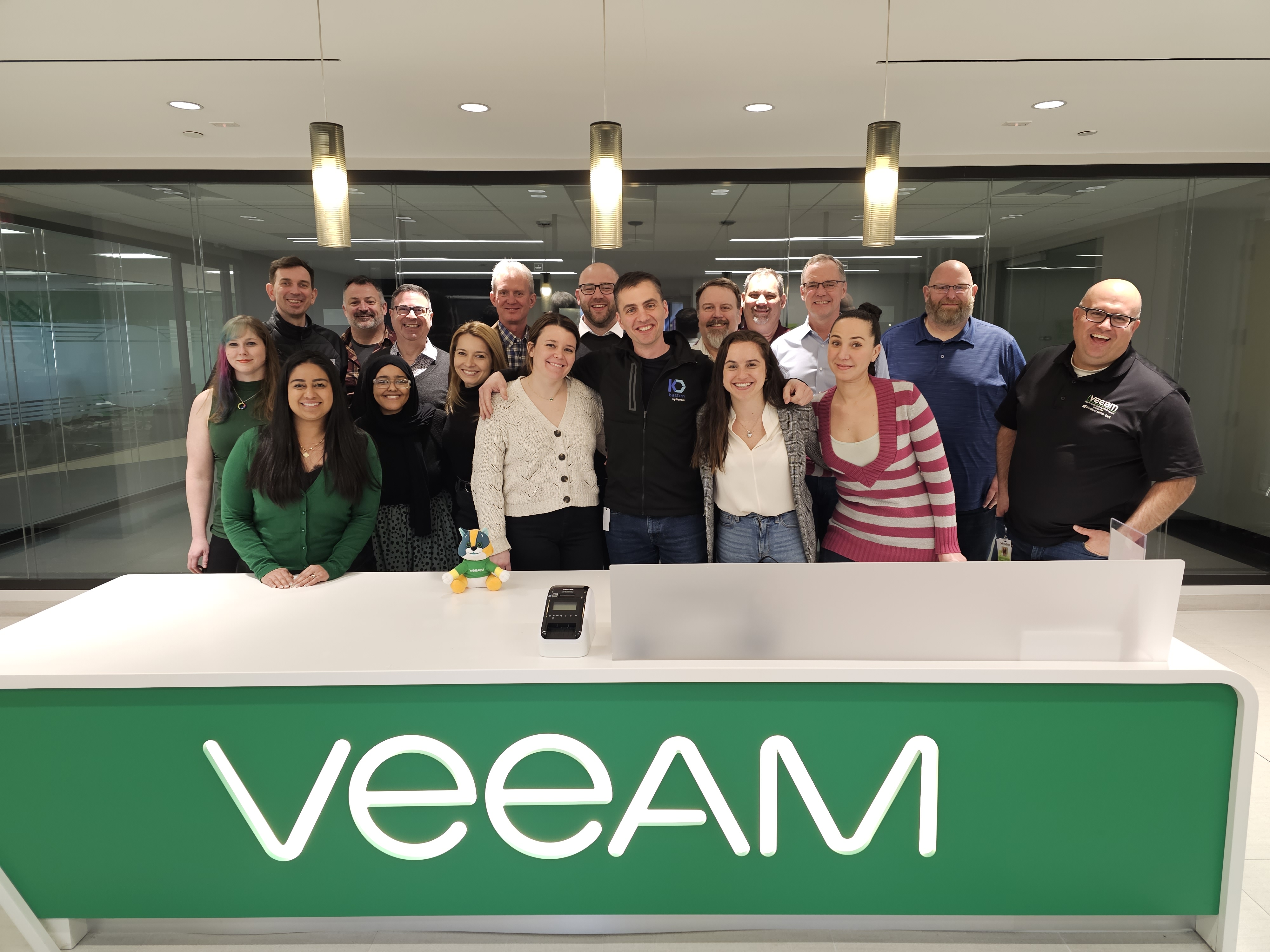 Veeam employees gathered in a bright office around a reception desk