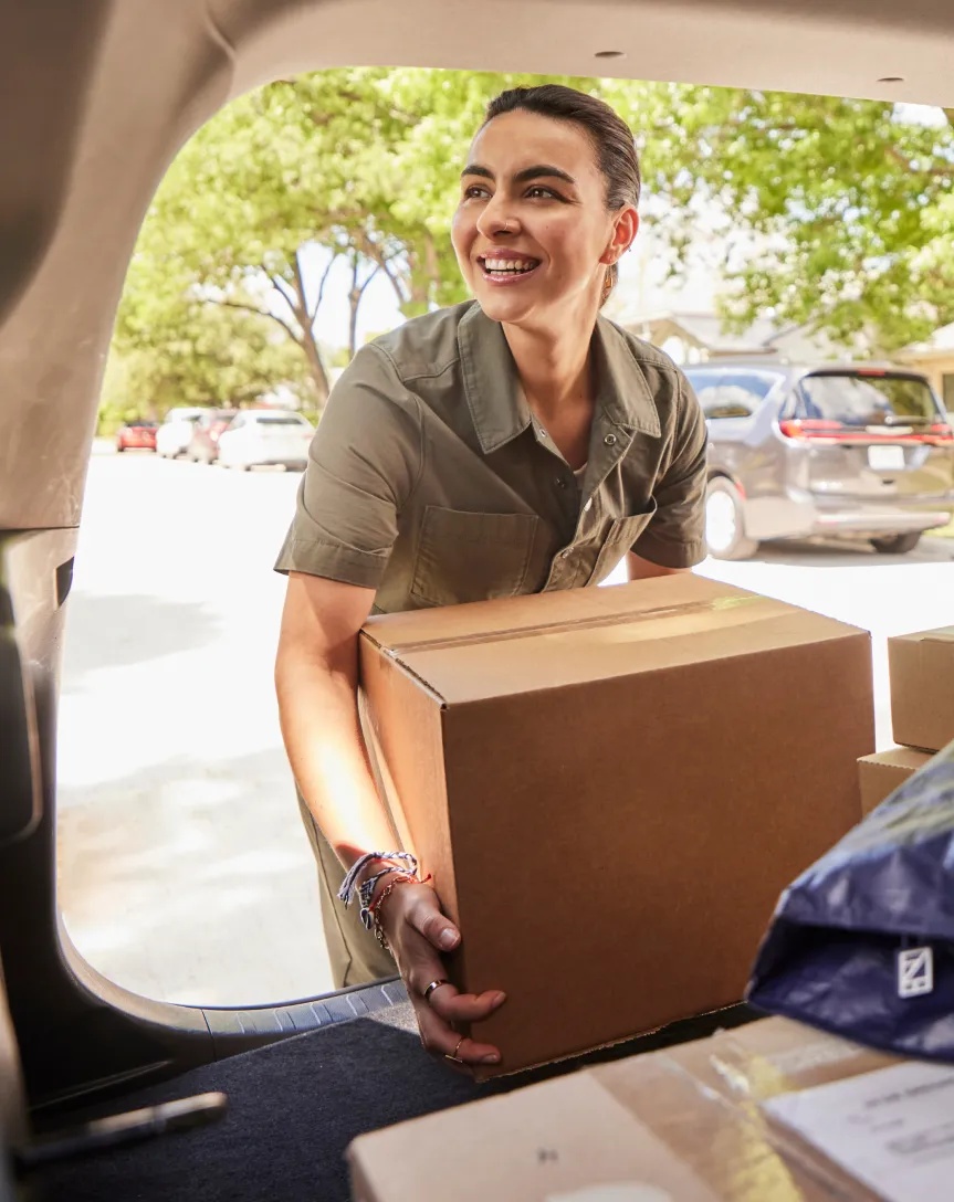 A Veho driver unloading a parcel from the back of a car