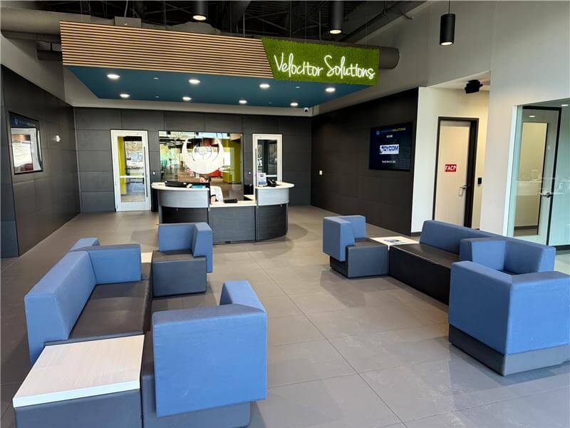 Velocitor Solutions office reception with blue seating and a reception desk