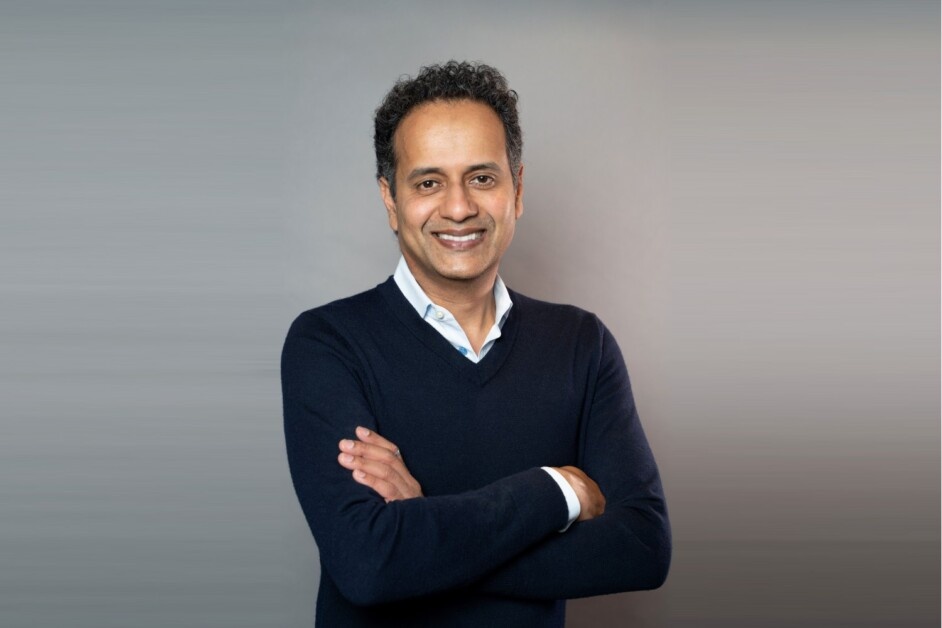 Ven Raju standing with his arms folded in a studio press photograph