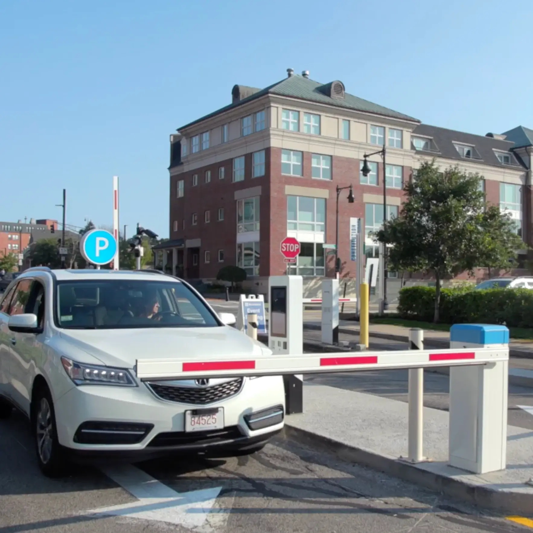White SUV beside a parking gate and digital kiosk in Vend’s access demonstration