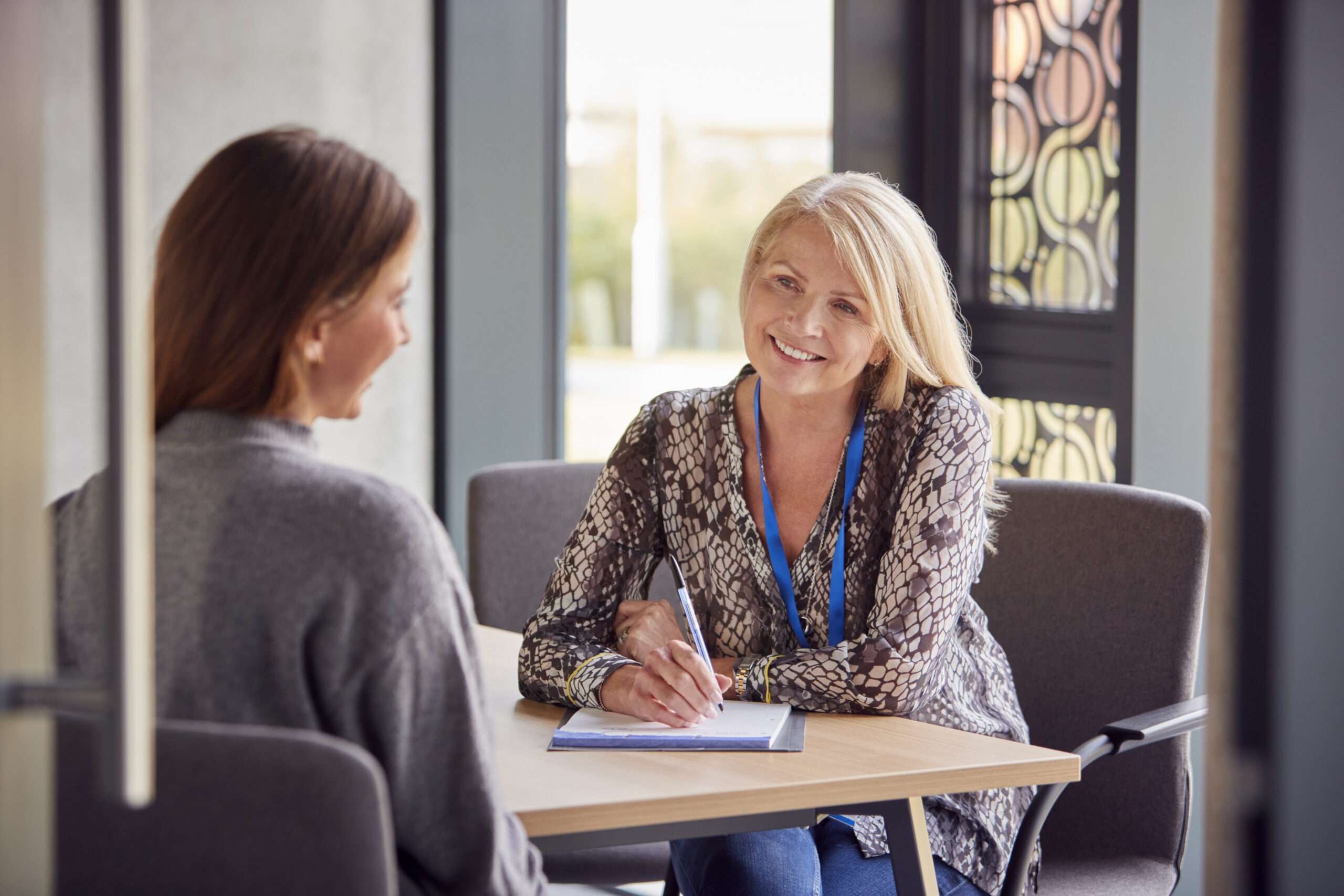 An illustrative photograph of two adults meeting across a table