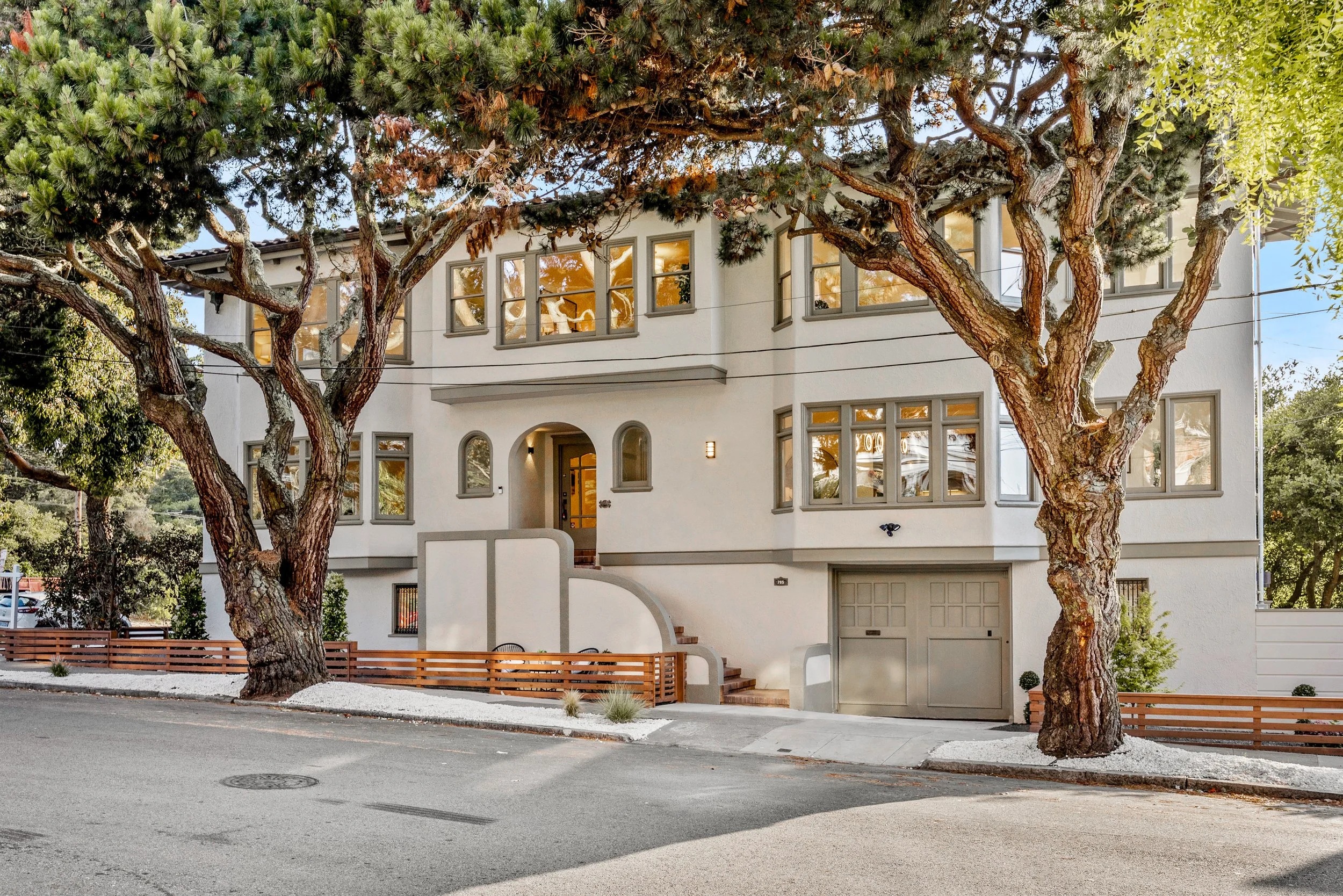 A cream-colored San Francisco home framed by mature street trees