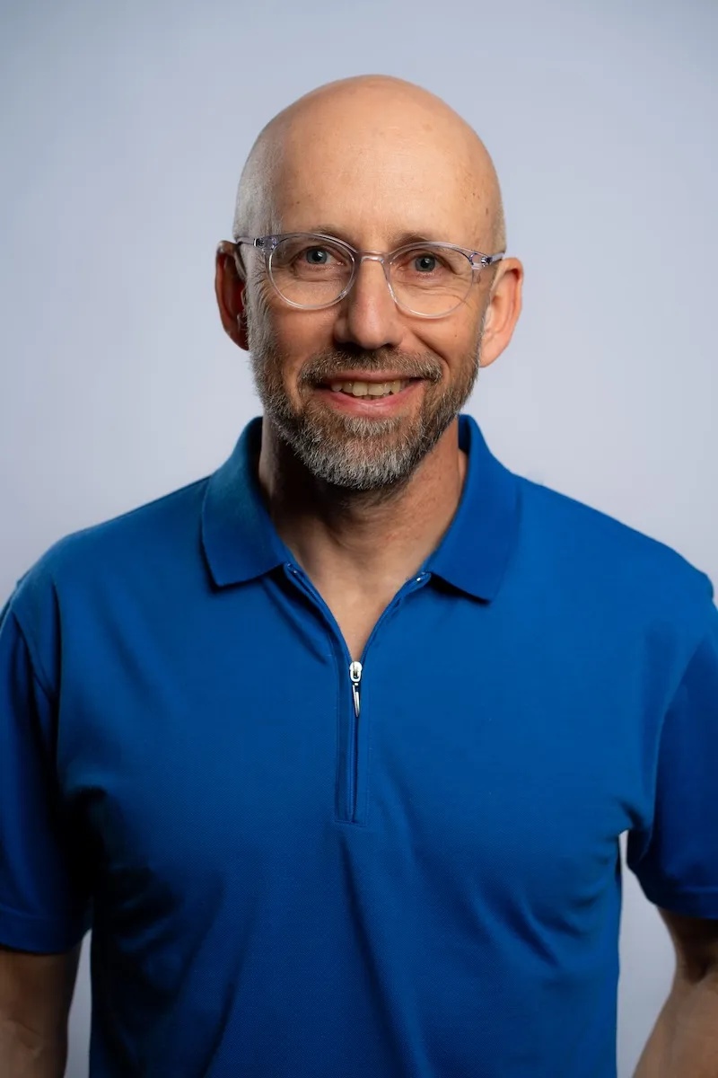 Verbit CEO Yair Amsterdam wearing glasses and a blue shirt