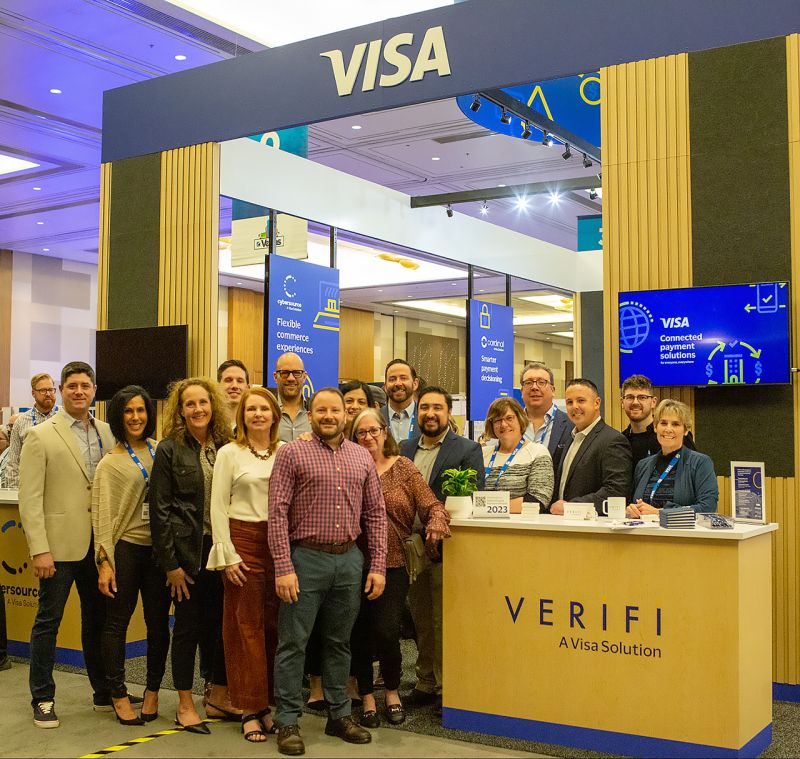 Verifi team posing at its Visa-branded stand at MRC Las Vegas 2023