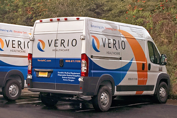 Verio Healthcare delivery vans in the company’s orange and blue livery