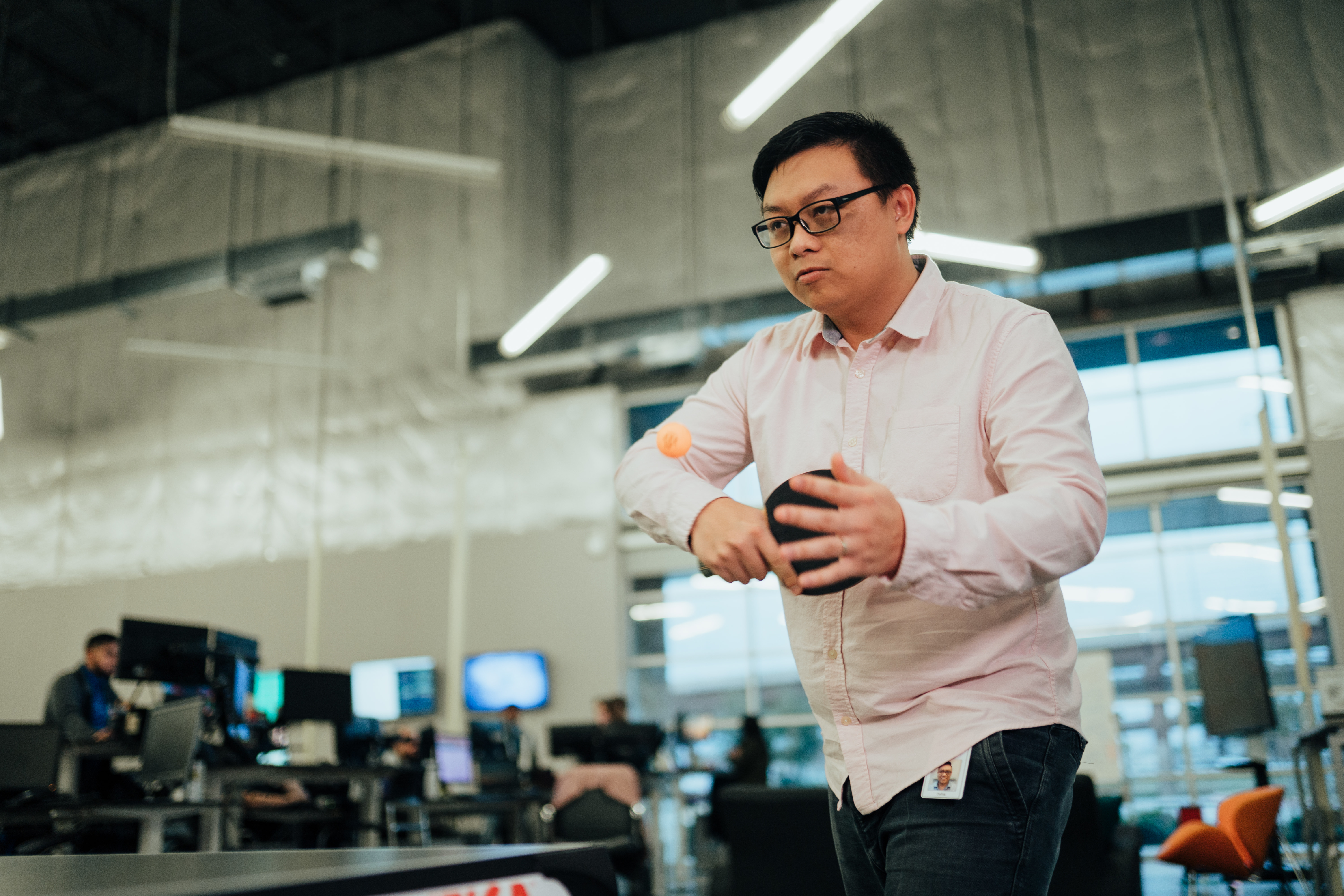 An employee playing table tennis inside ViaTech’s open Dallas office