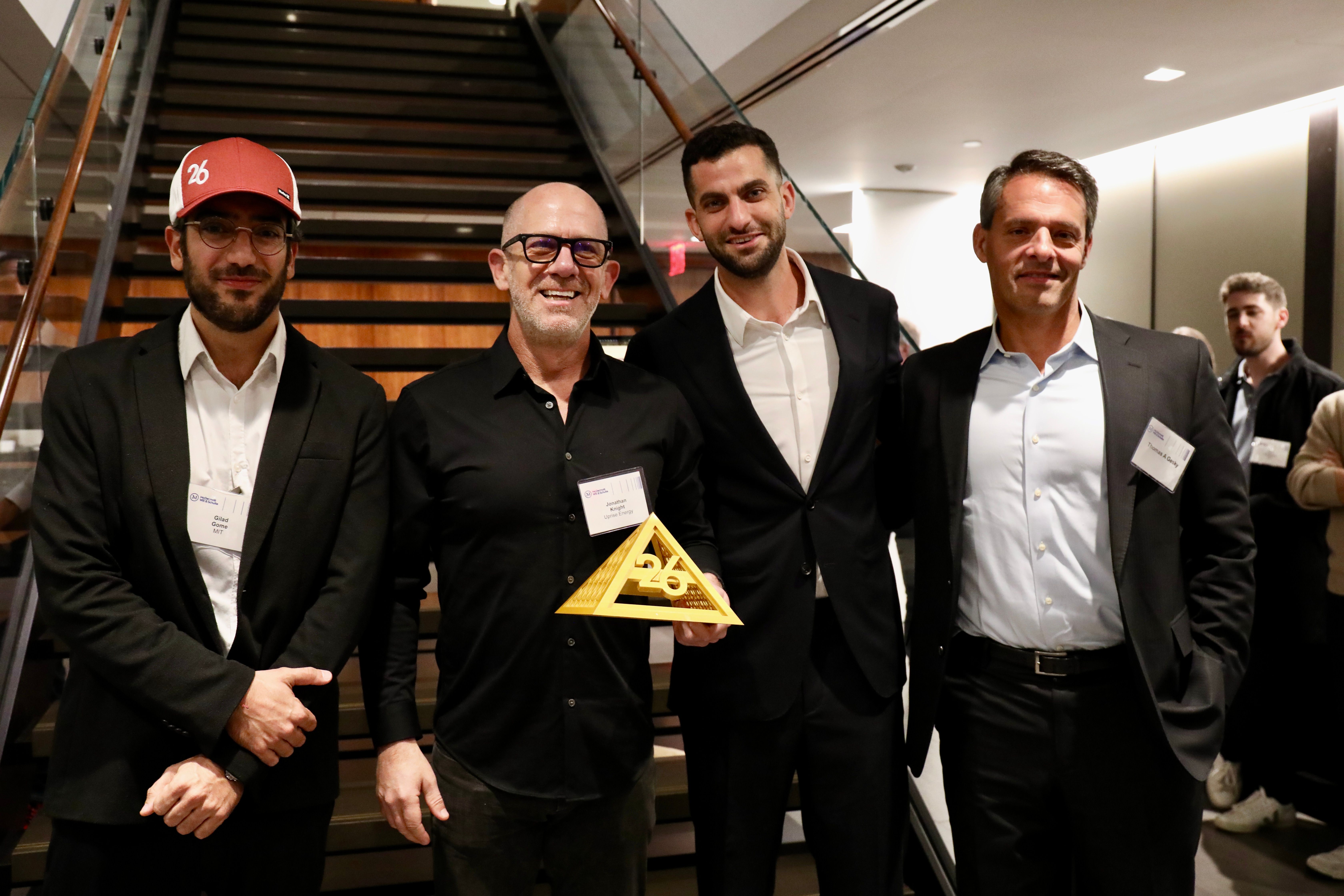 Four FutureMakers attendees pose with the TwentySix Ventures trophy beside a staircase