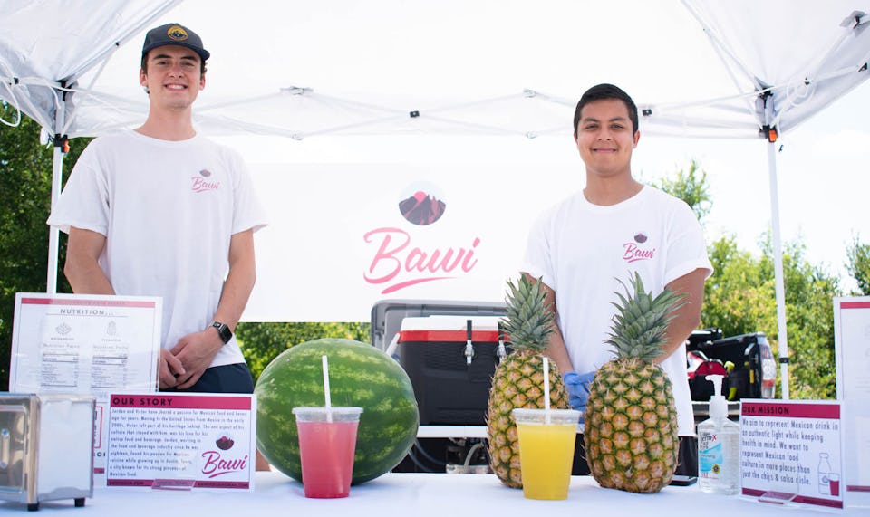 Jordan Hicks, left, and Victor Guardiola, right, at an early Bawi farmers market stand