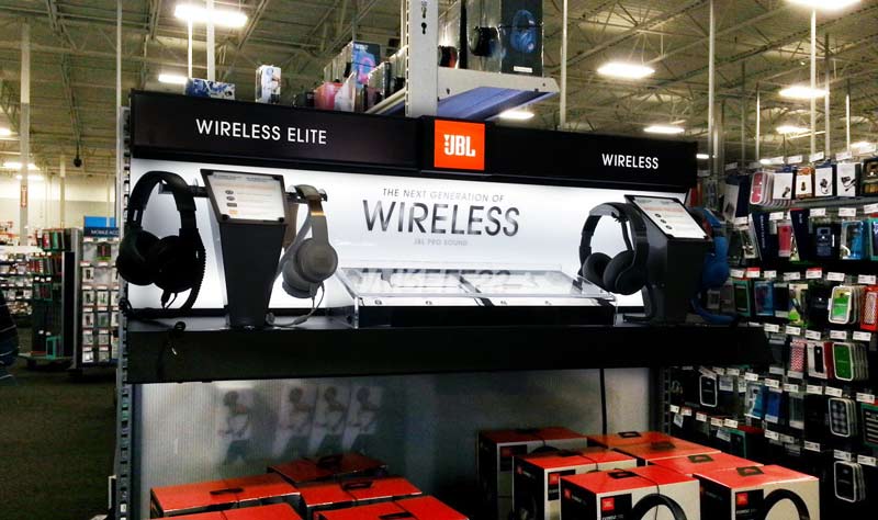JBL headphone demonstration fixture installed above boxed headphones in a store