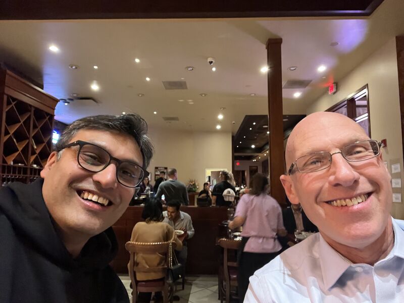 Vidur Mahajan, left, and Morris Panner smiling together at a restaurant