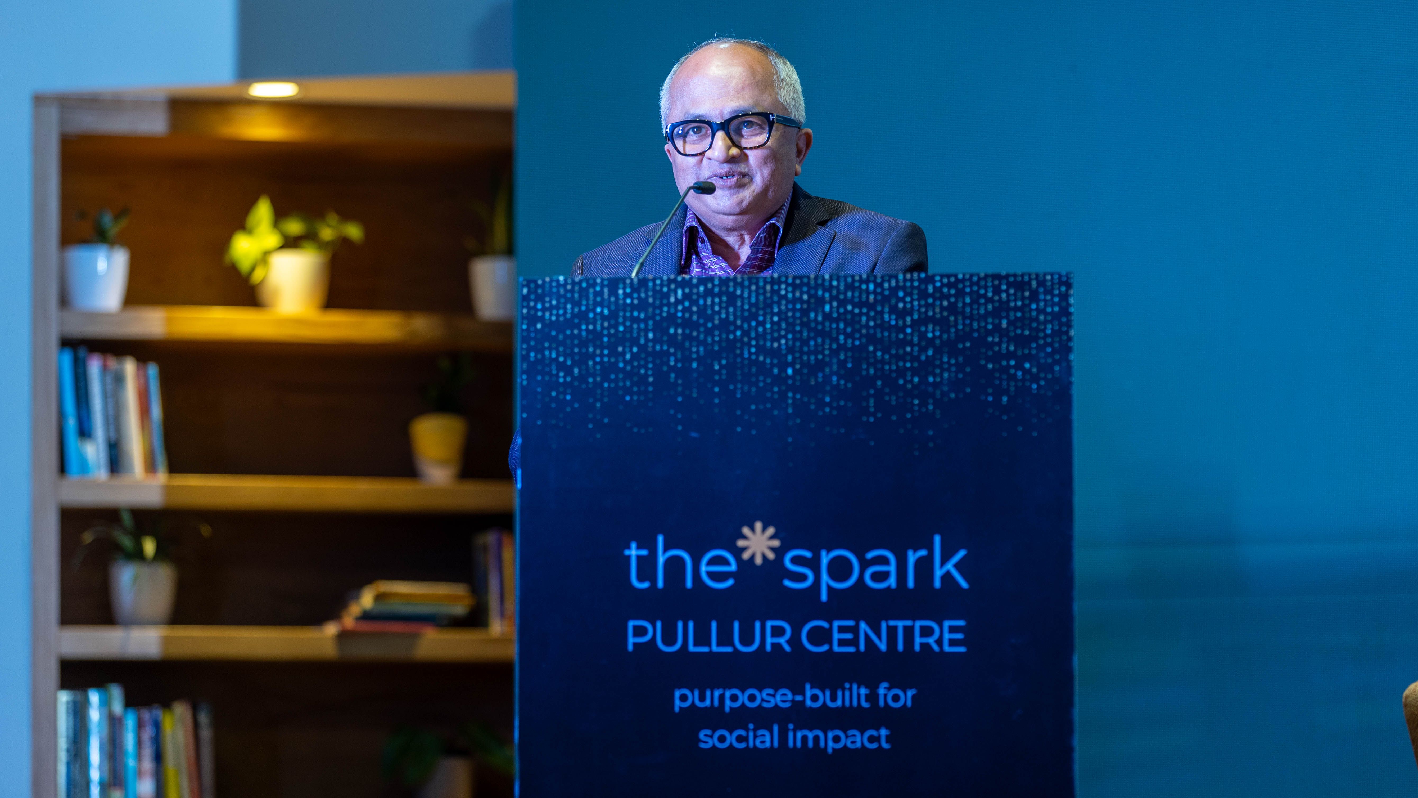 Vijay Pullur speaking behind the podium at the launch of the spark Pullur Centre in Bengaluru
