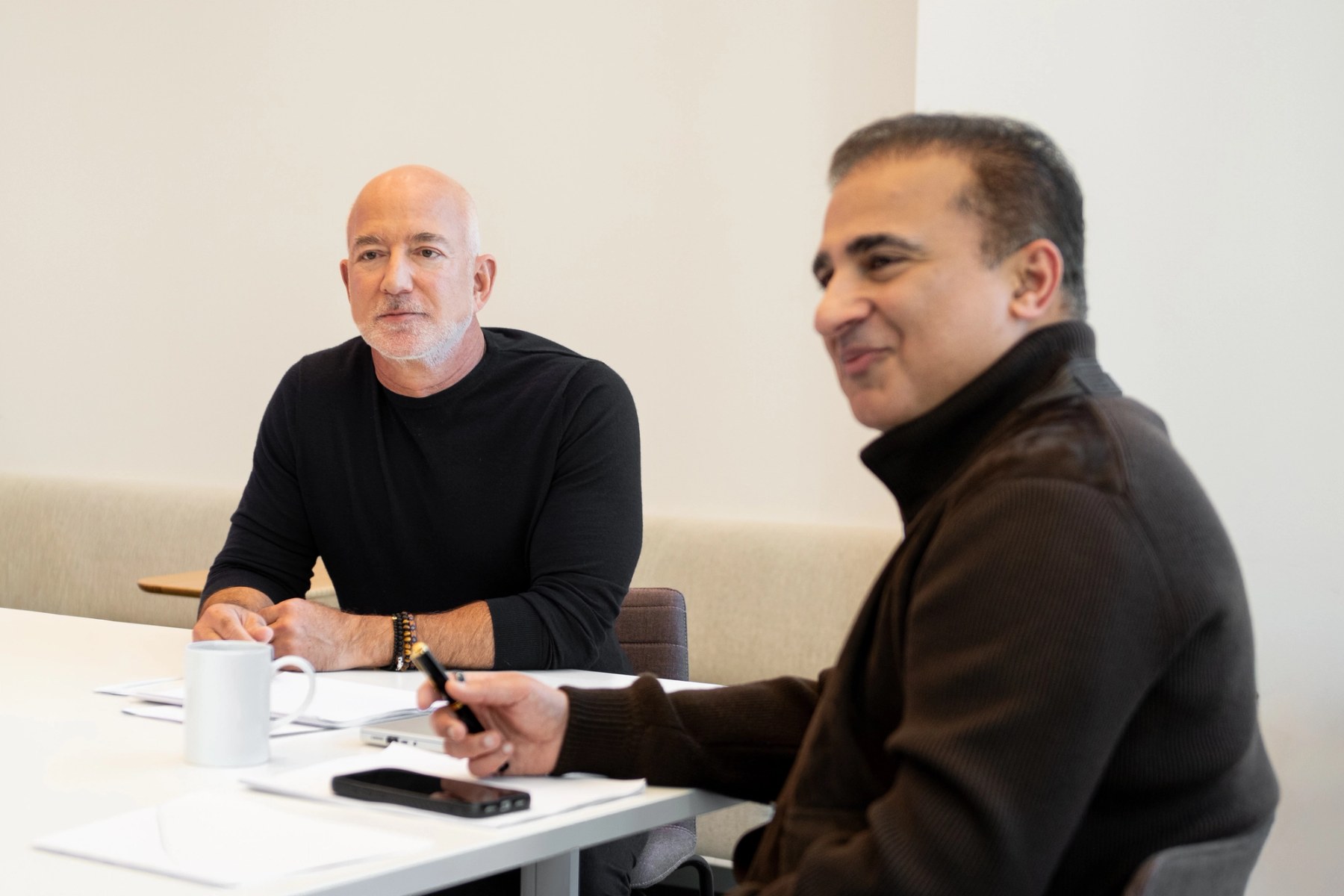 Jeff Bezos and Vik Bajaj seated together at a table during a Prometheus interview
