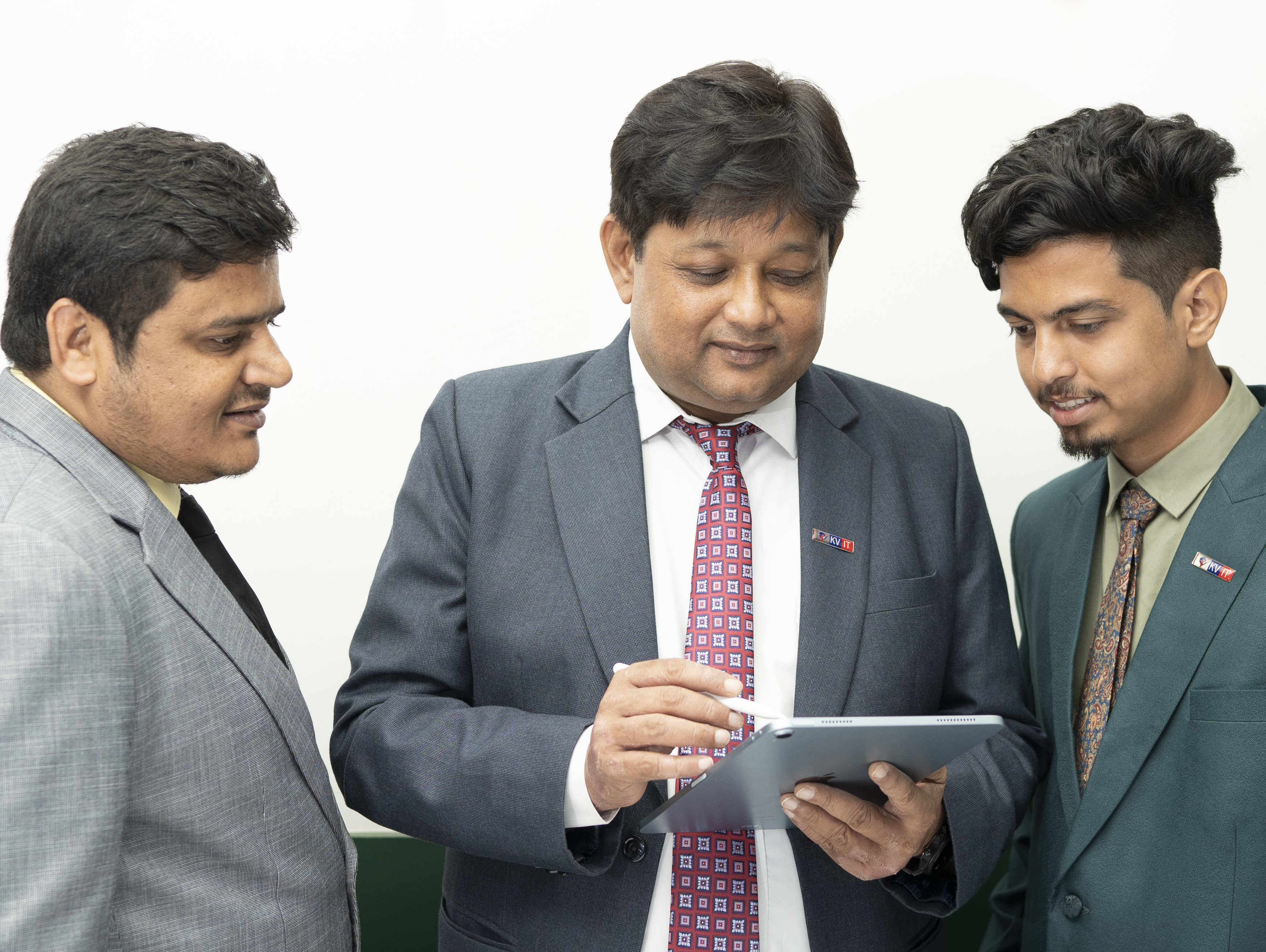 Vikas Debnath in the centre of three colleagues looking at a tablet