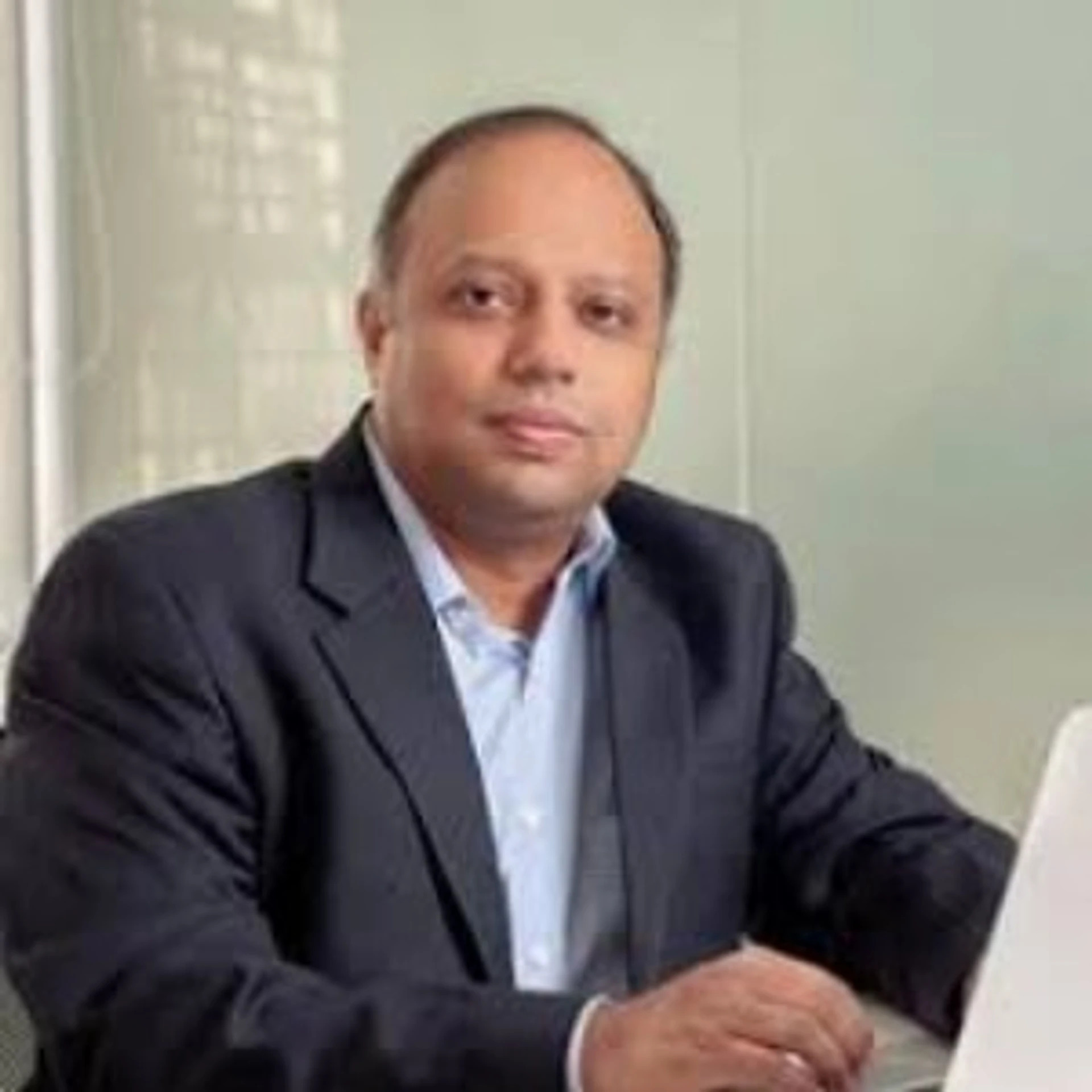 Vinay Nathan seated at a table in a dark jacket