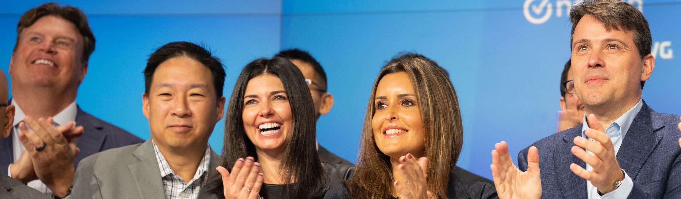 Vincent Pilette, at far right, applauding with colleagues against a blue event backdrop