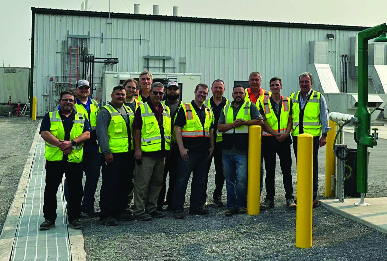 OneD’s production team in high-visibility vests outside its Moses Lake facility; Vincent Pluvinage stands at the far right.
