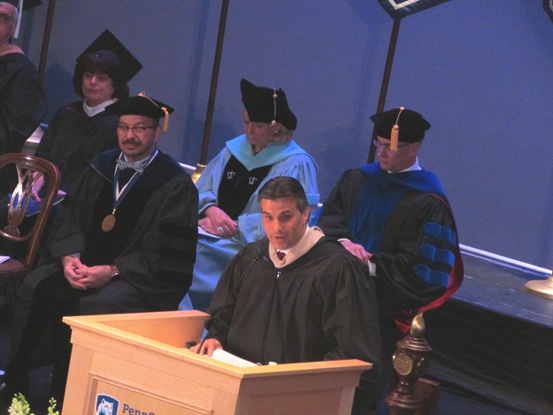 Vincent Sorgi in academic robes speaking at a lectern during Penn State Worthington Scranton’s 2017 commencement