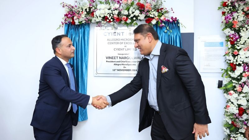 Vineet Nargolwala and Krishna Bodanapu shake hands beside the Hyderabad center inauguration plaque