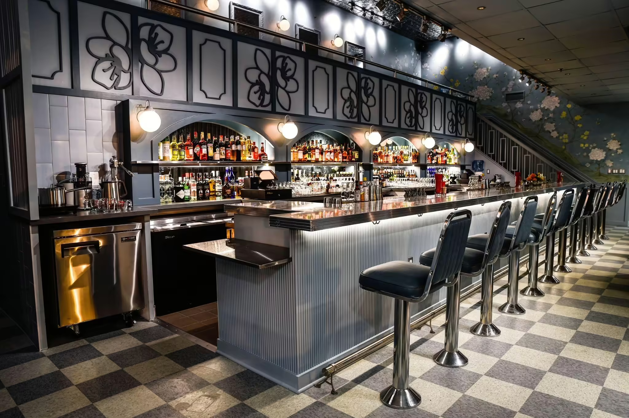 Morris American Bar’s floral walls, illuminated arches, and long cocktail counter