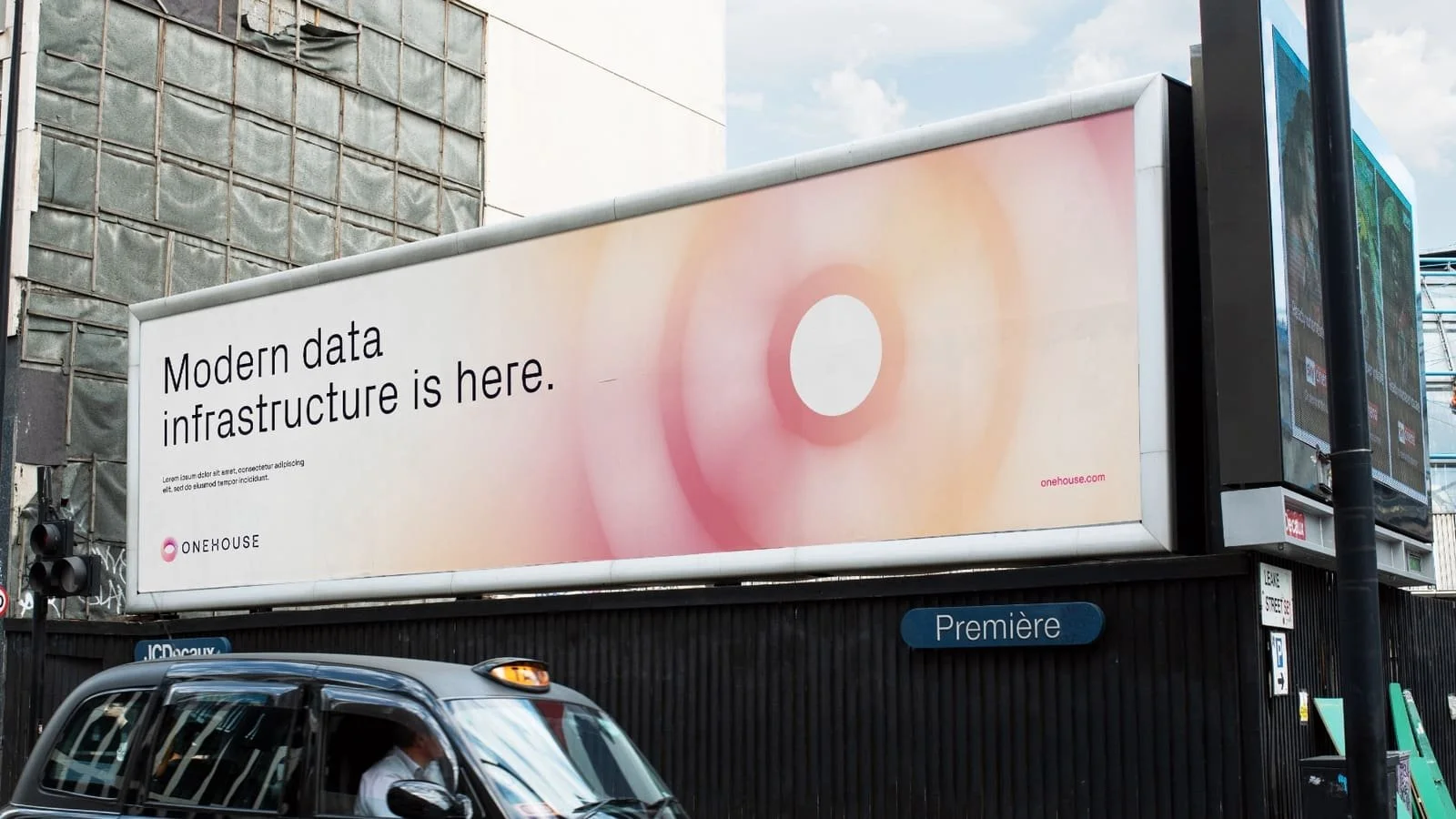 Onehouse launch advertising on a street billboard above a taxi