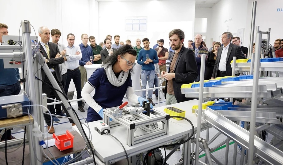 Visitors watch a workstation demonstration at the Betterguards production site opening