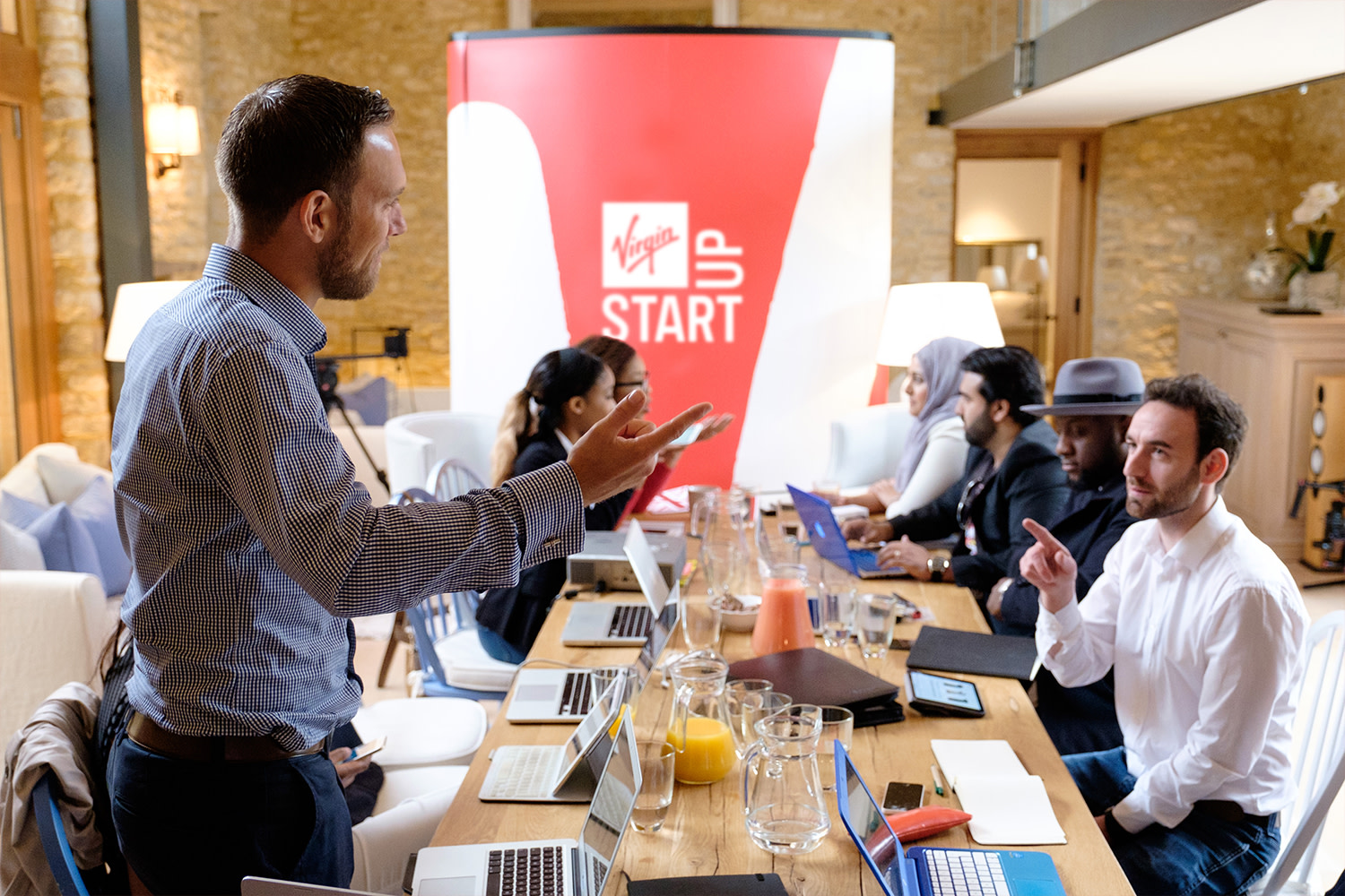 A Virgin StartUp workshop with participants discussing ideas around a table