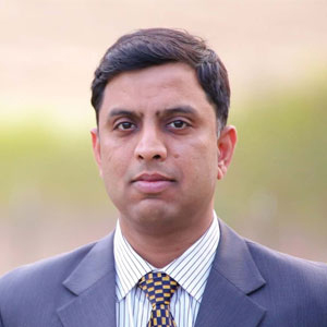 Vishnu Datla in a suit and patterned tie in an AutoRABIT press portrait