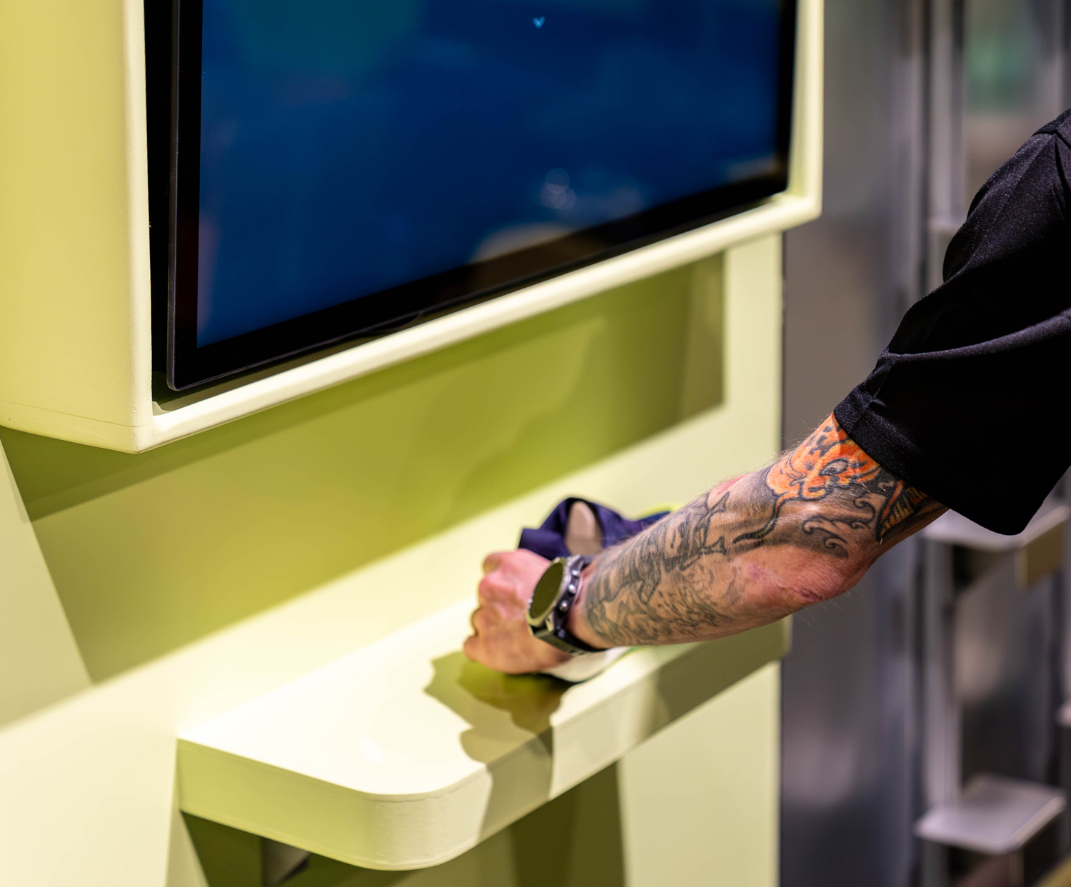 A hand places a running shoe beneath an interactive screen at House of SportsShoes