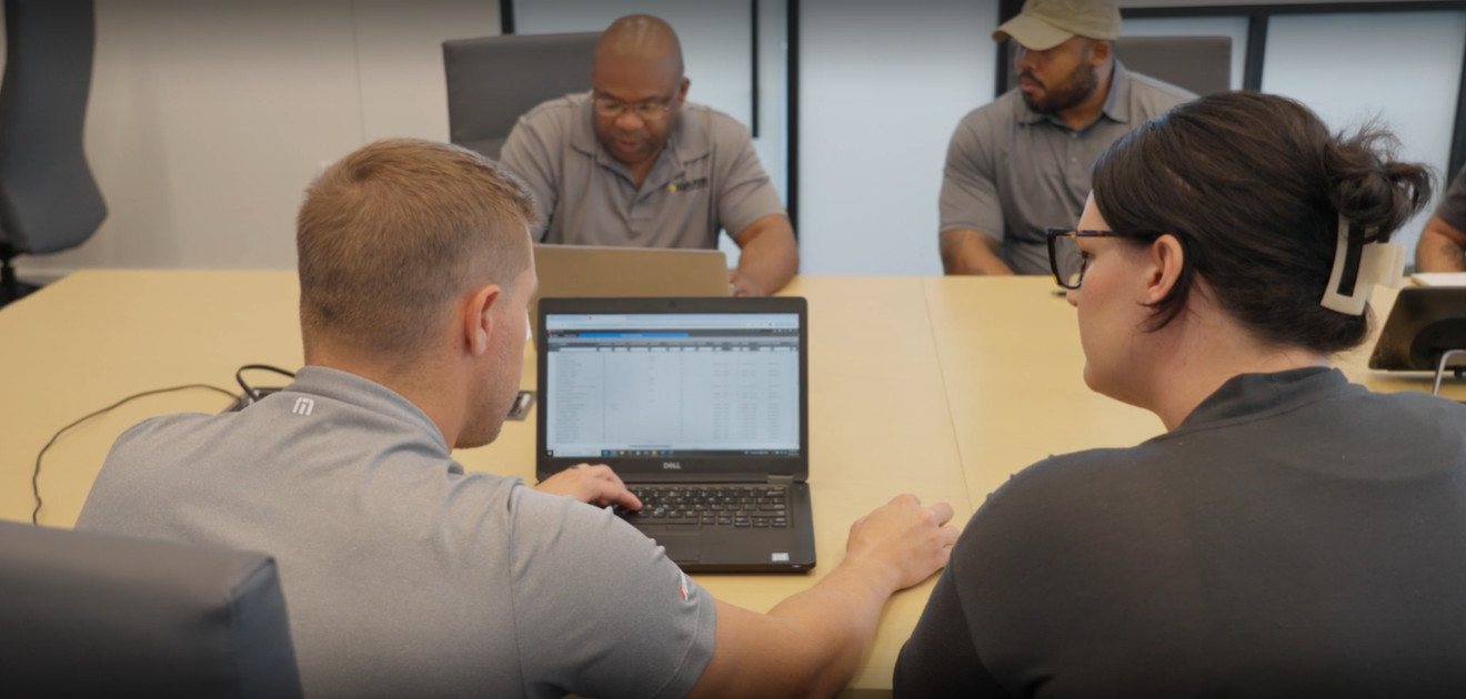 Darr Equipment employees reviewing e-Emphasys ERP together at a table
