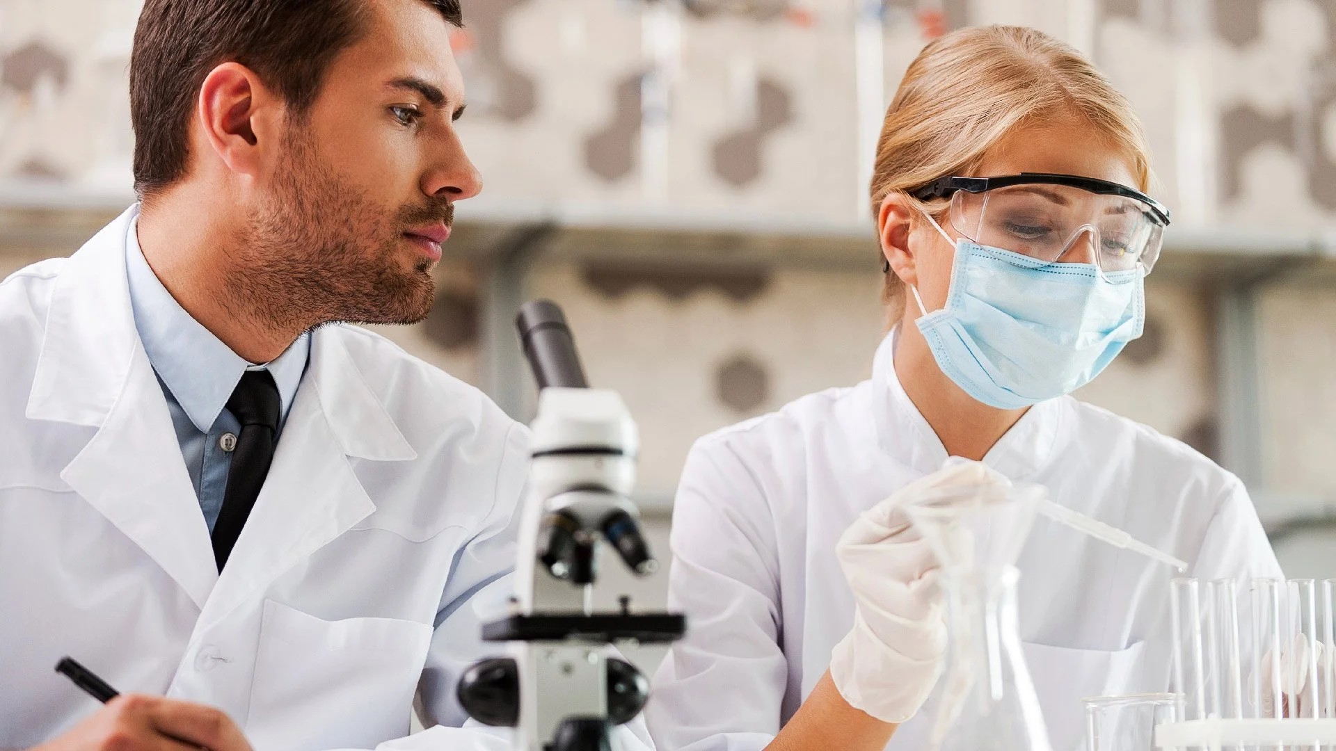 Two scientists in a pharmaceutical laboratory examining samples