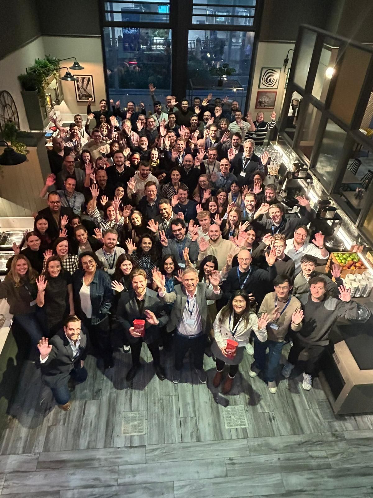 Vixio team members gathered together, looking up and waving at the camera
