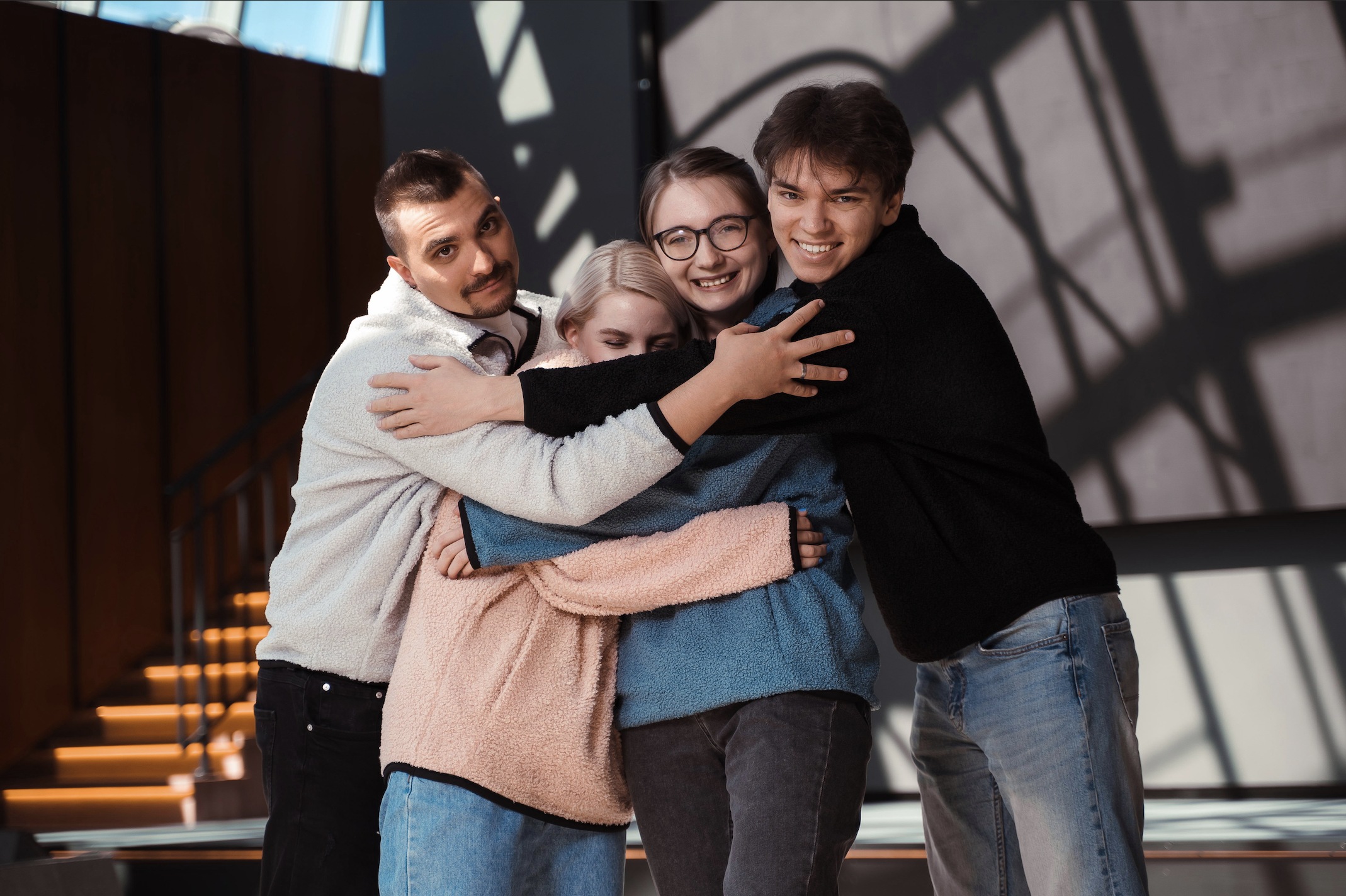 Four people embracing in a VK recruitment photograph