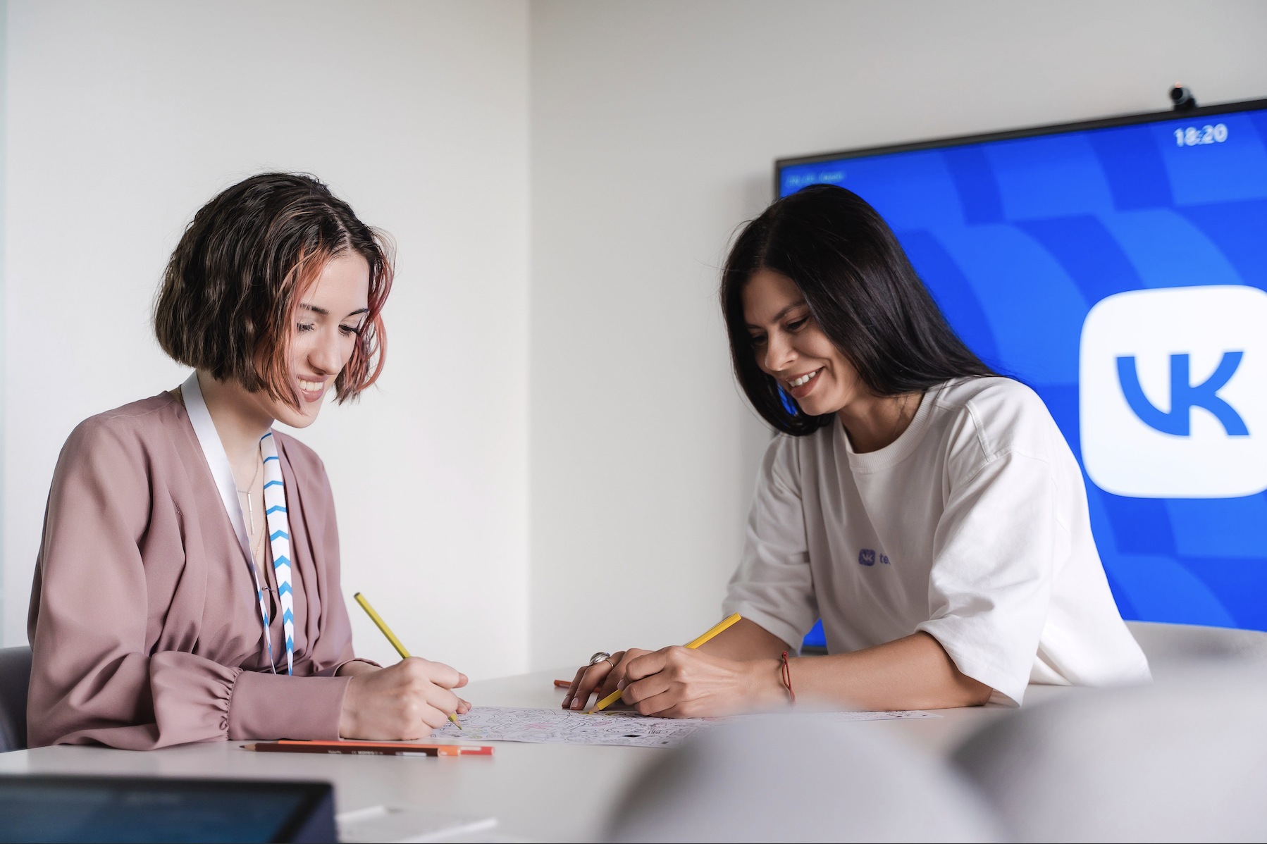 Two people working together at a table in a VK recruitment photograph