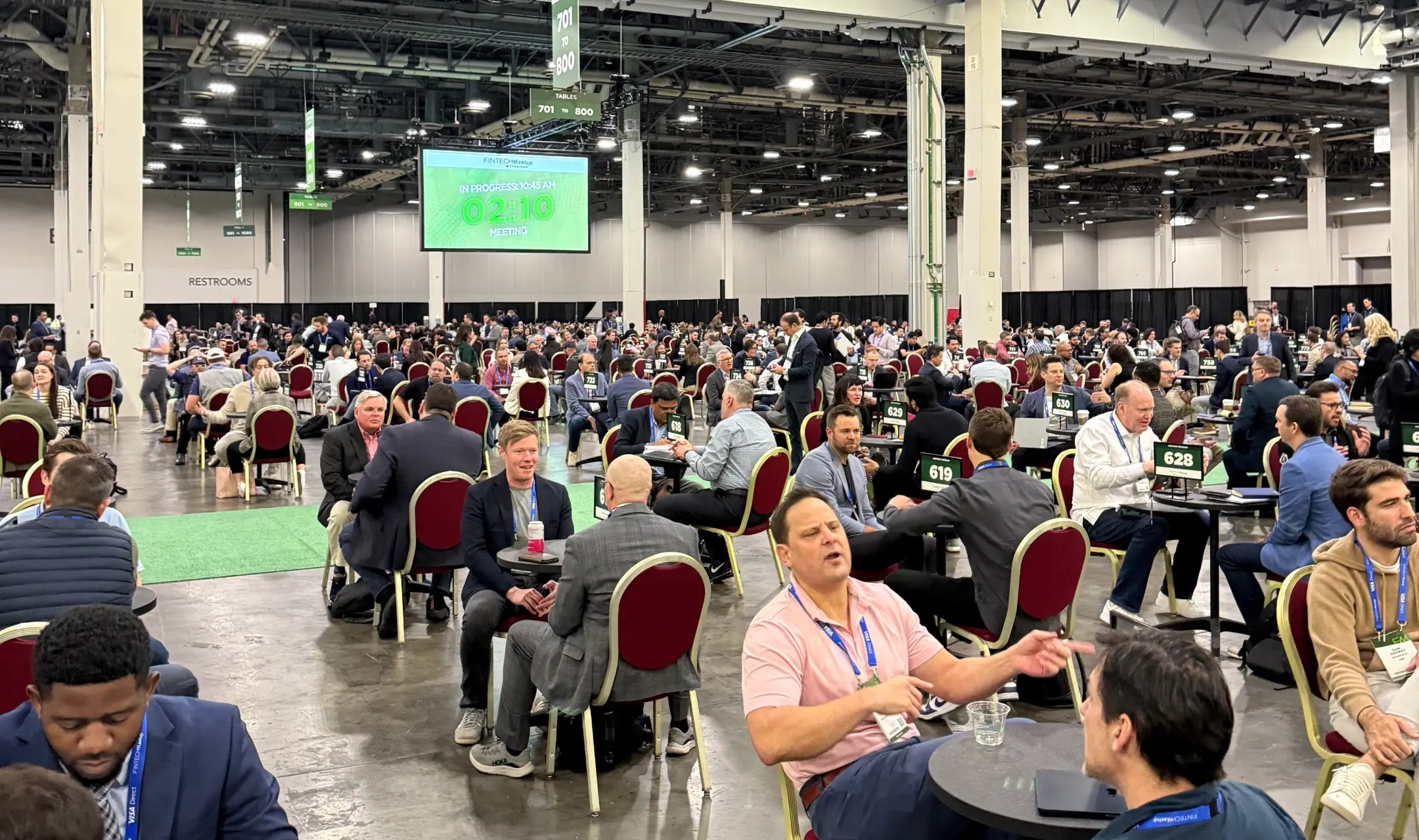 Rows of small discussion tables on the Fintech Meetup conference floor