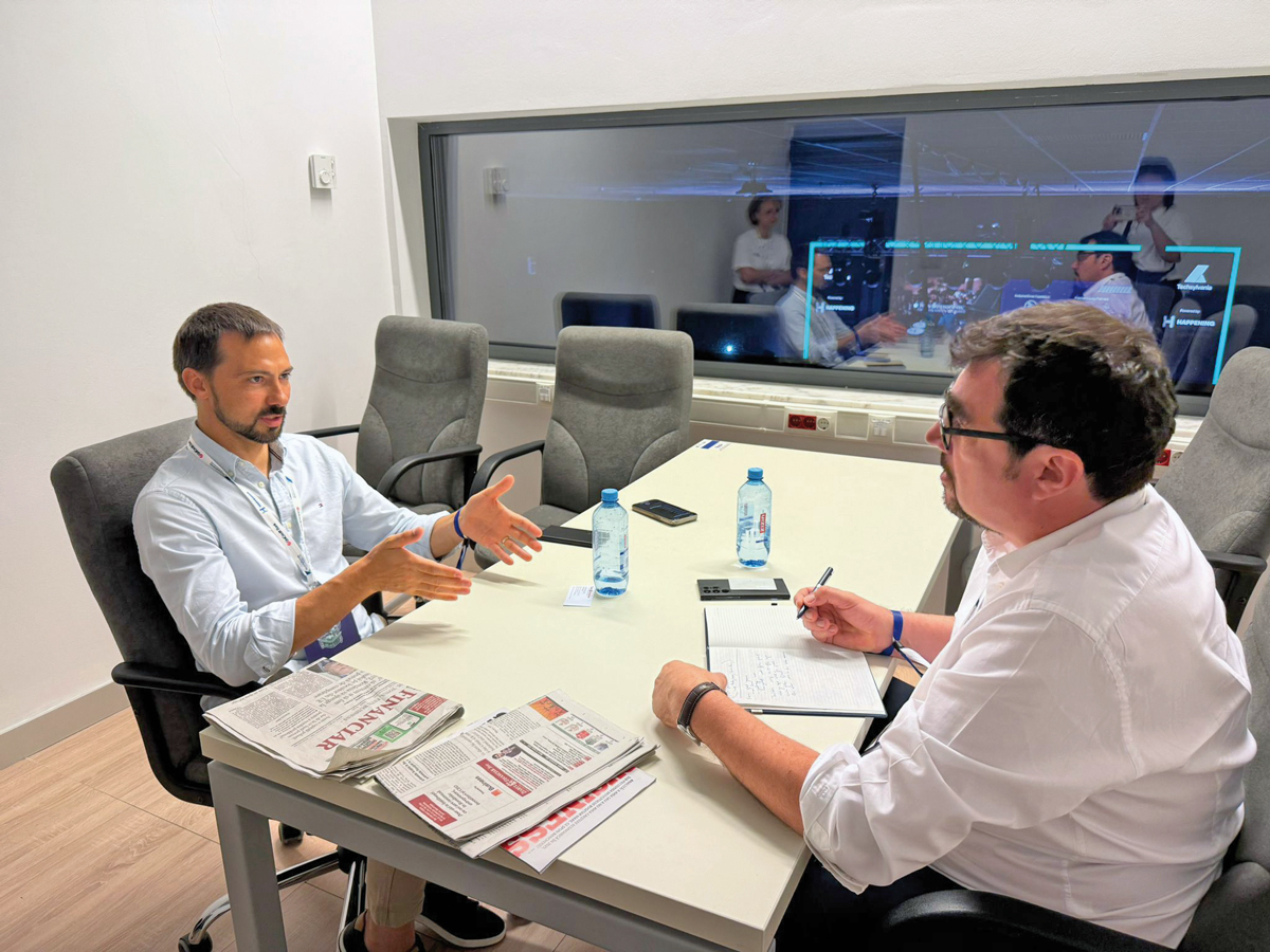 Vlad Yatsenko speaking across a table during an interview in 2025