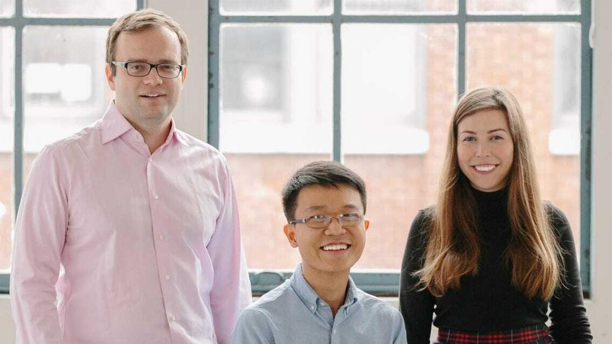 Lunchclub cofounders Vladimir Novakovski, Scott Wu, and Hayley Leibson standing together in front of office windows