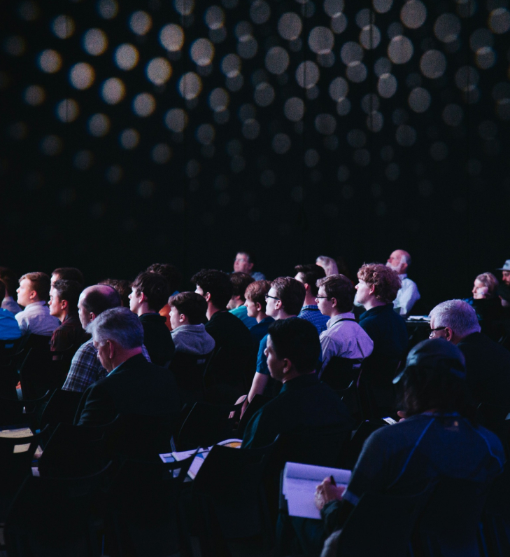 Seated audience listening at an event in a photograph published by VNTR