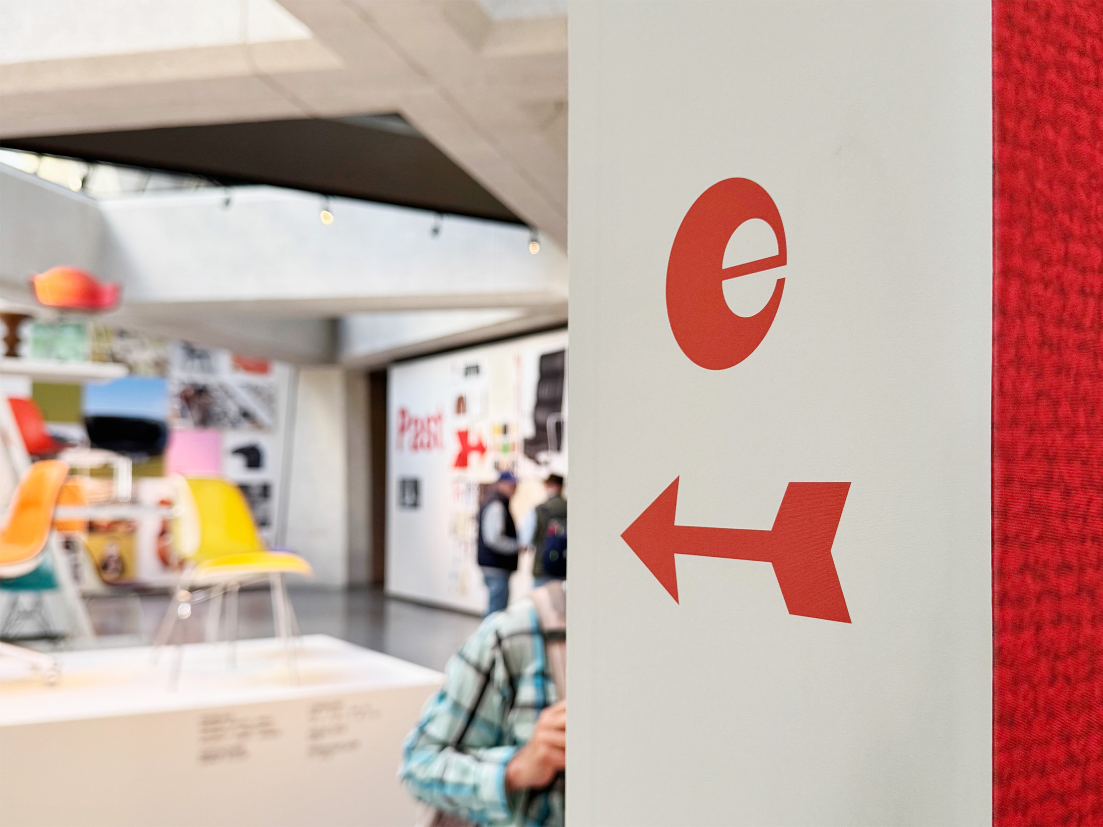 A red Eames symbol and directional arrow inside the furniture exhibition