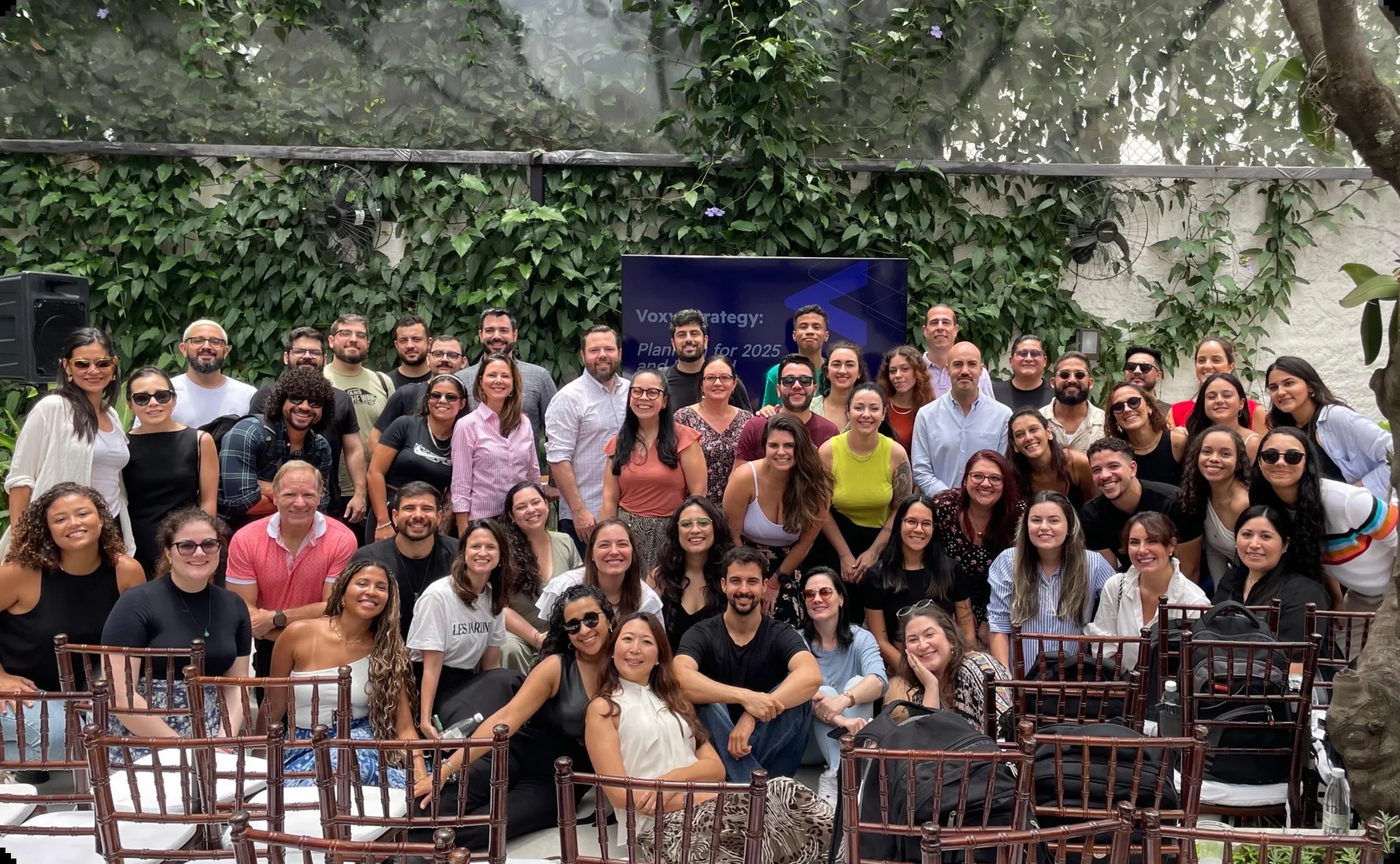Voxy colleagues gathered for a group photograph in a leafy courtyard