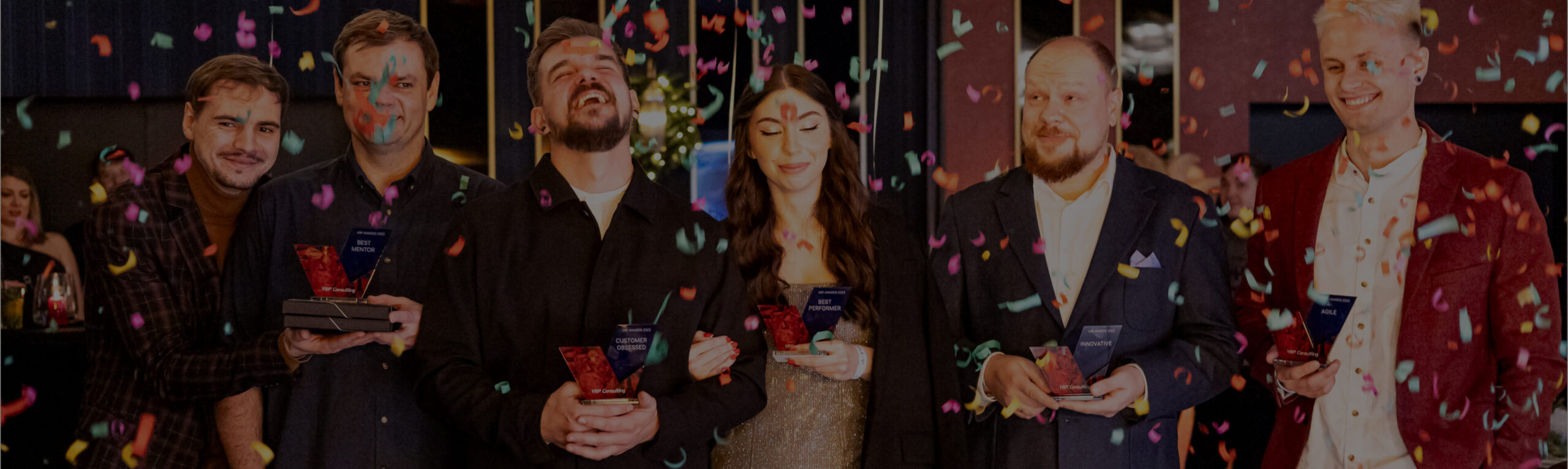 VRP colleagues holding employee awards as confetti falls at a company celebration