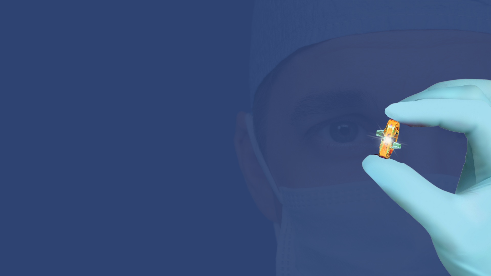 A gloved hand holding the small gold VYRSA V1 sacroiliac fusion implant